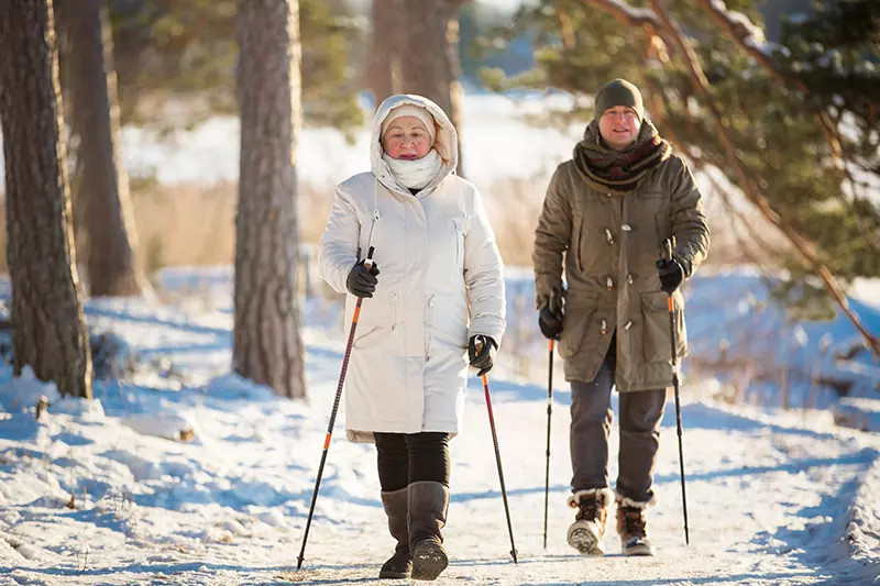 Older adults walking in winter Minnesota weather with skin protection